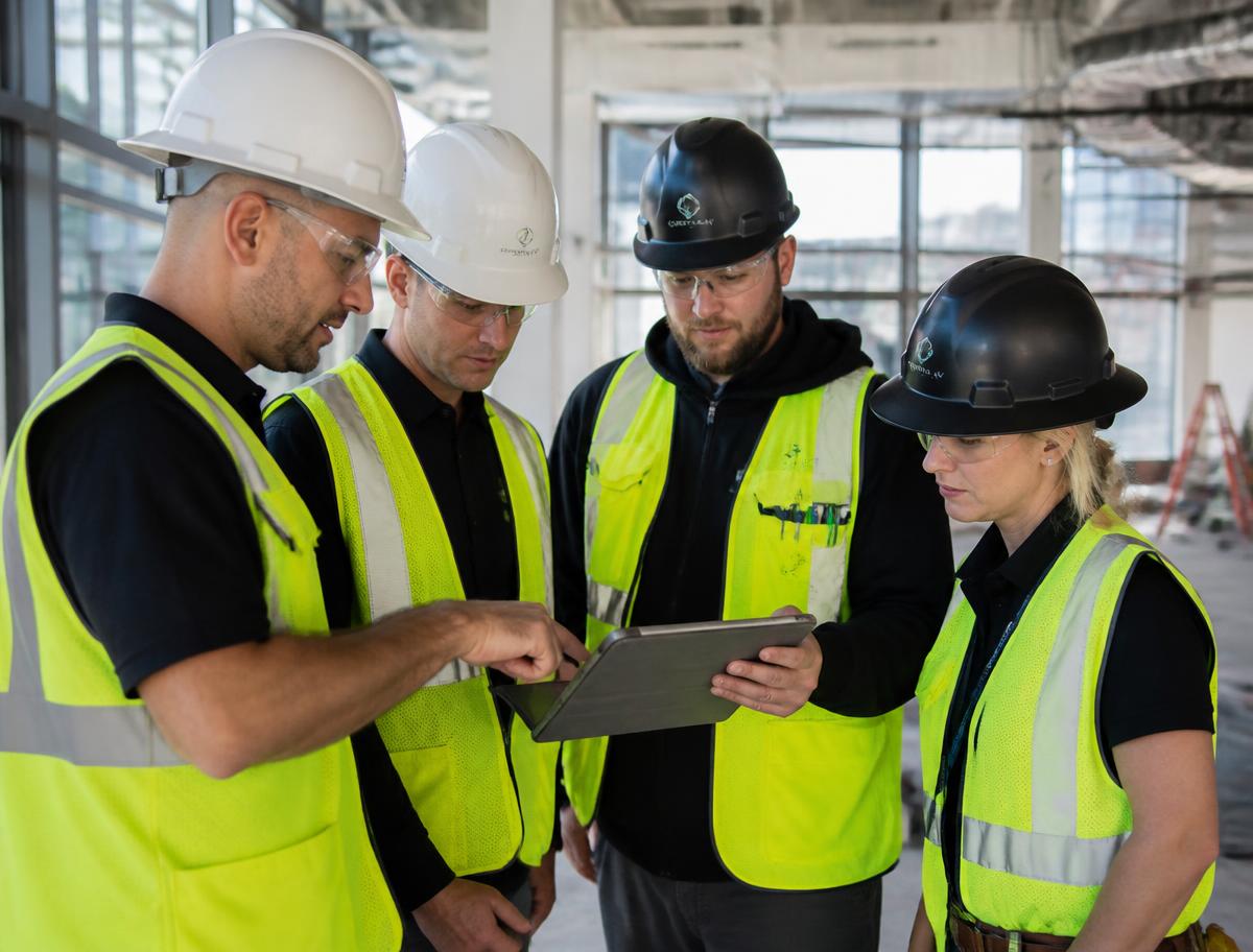 Crew of contractors reviewing plans together on a tablet